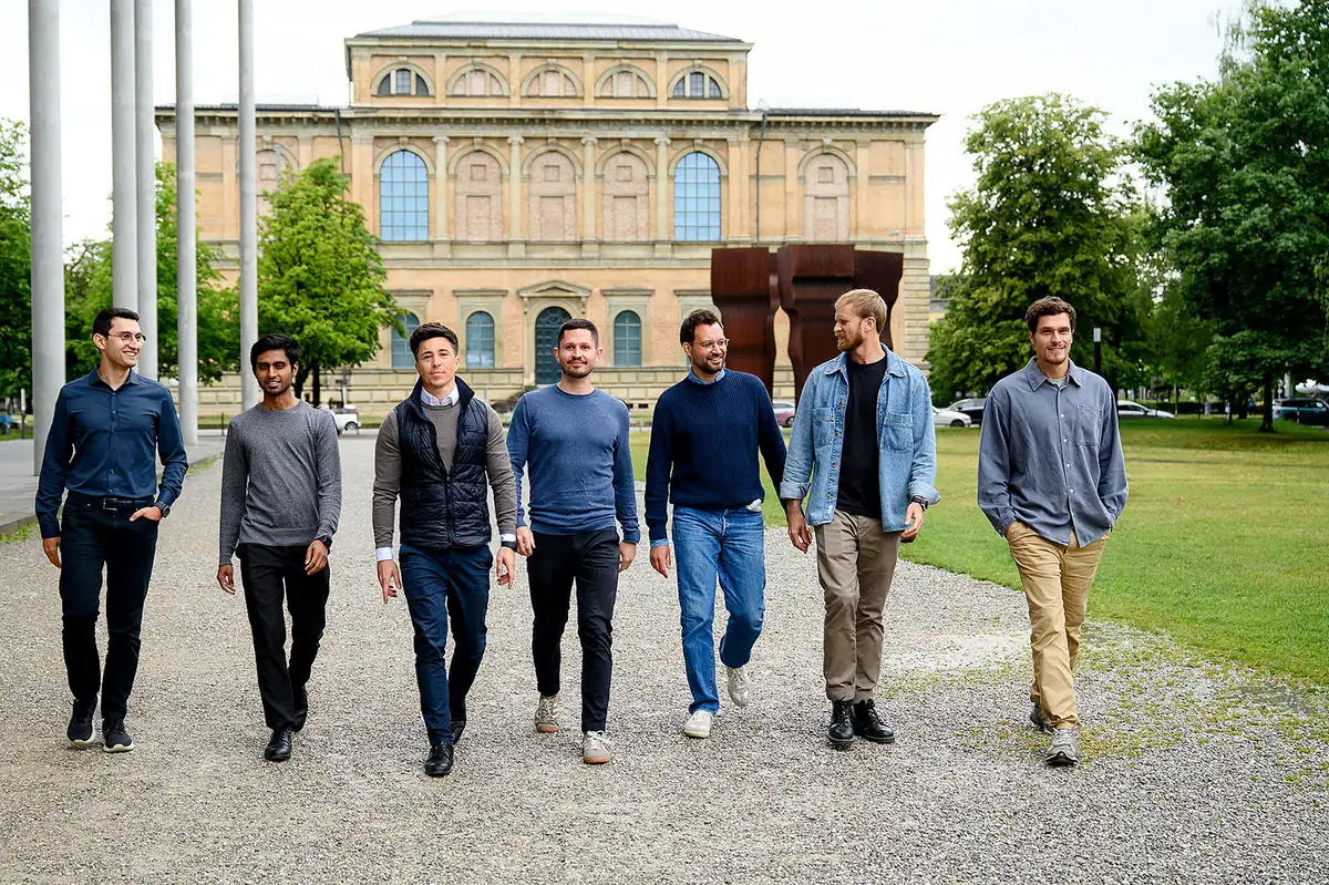 Das Team von Lextract auf einem Kiesweg vor einem Museumsbau in München